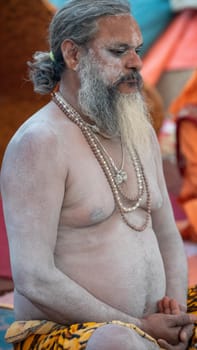 Haridwar, Uttarakhand, India April 12, 2021. Indian Saints in their traditional way of Yog Mudra, meditating. Sitting in silence as part of the initiation of new sadhus during Kumbha Mela. The Naga Sadhus.