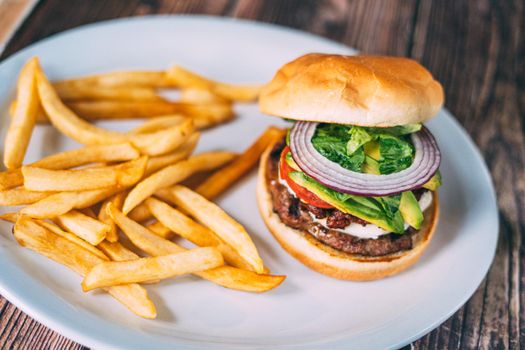 A plate of juicy hamburger and fries