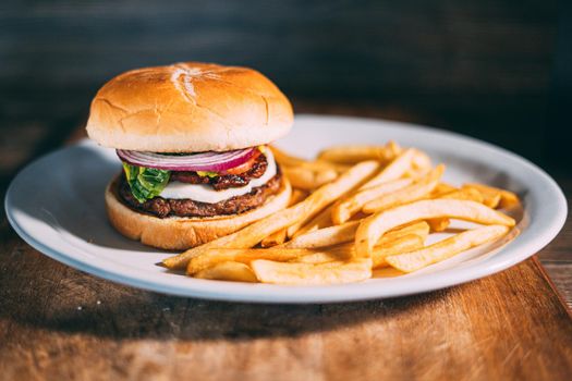 A plate of juicy hamburger and fries