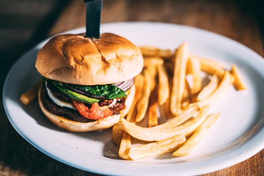 A plate of juicy hamburger and fries