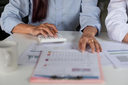 Close up accountant working on desk using calculator for calculate finance report in office