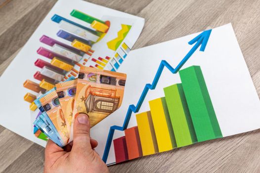 hand of man counting money from 50 euros with statistics background