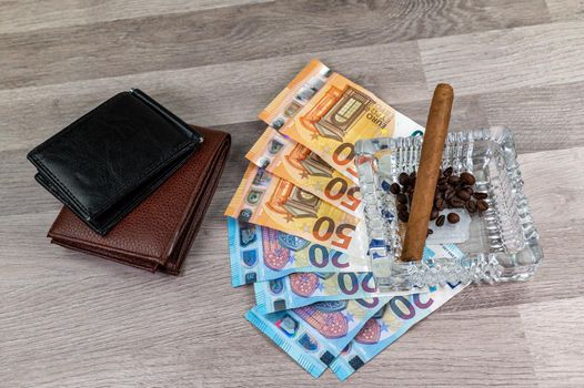 20 and 50 euro banknotes and wallet and cigar on wood background