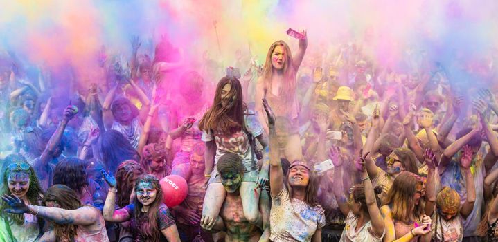 Holi colors holiday. Crazy crowd of young people having fun during festival of colors ColorFest in Kyiv, Ukraine