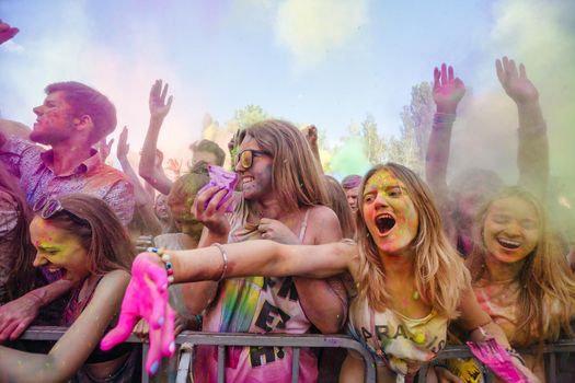 Holi colors holiday. Crazy crowd of young people having fun during festival of colors ColorFest in Kyiv, Ukraine