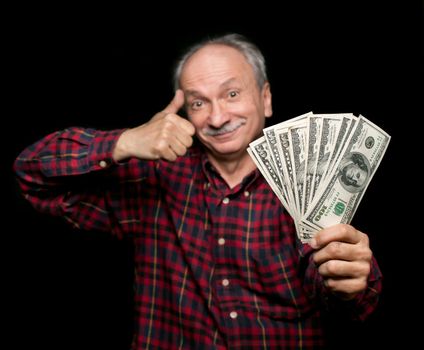 Happy elderly man showing fan of money and sign OK with fingers