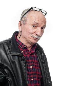 Portrait of a skeptical elderly man with glasses and a leather jacket on a white background