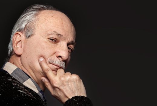 Portrait of handsome senior man with a tired expression on gray background with copy-space