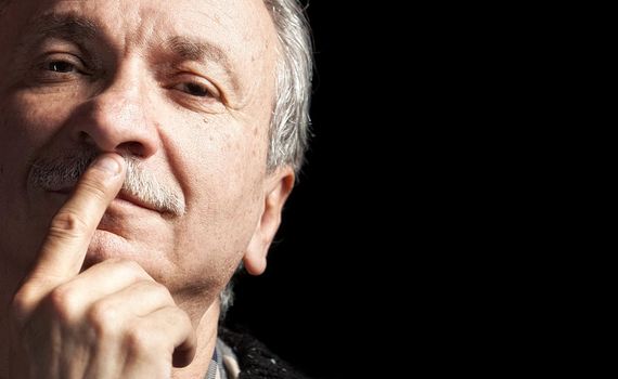 Portrait of handsome senior man with a tired expression isolated on black with copy-space