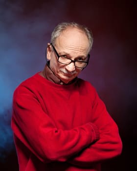 Portrait of an elderly man wearing glasses and a red sweater