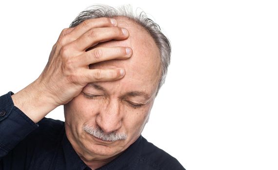 Elderly man suffering from a headache isolated on white background with copy-space
