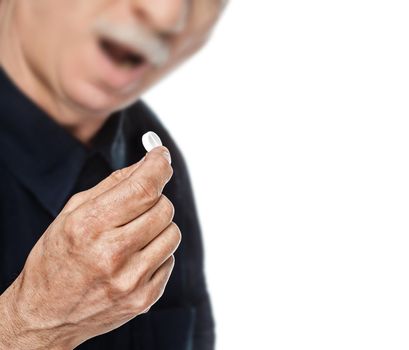 Old man wants to take a pill. Focus on hand. Isolated on white background with copy-space