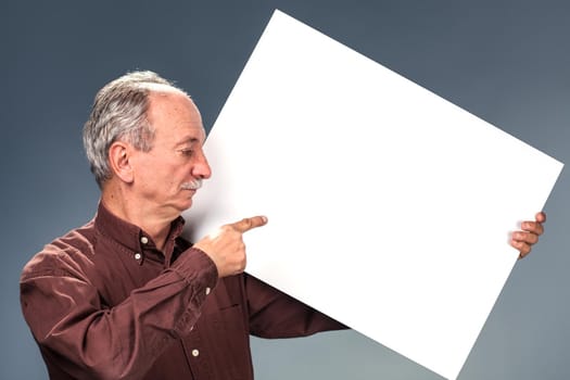 An elderly man holding a blank billboard