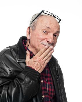 Confused elderly man covers his mouth with his hand