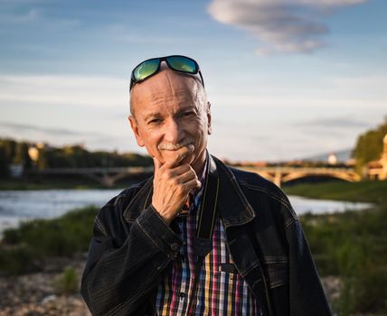 Life style concept. Old man. Portrait of a wise, skeptical and tired of life elderly man on a natural background