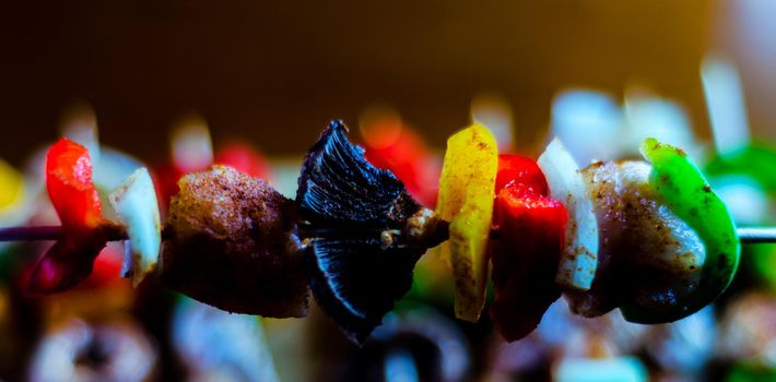 skewers with meat and vegetables prepared for grilling on a wooden board, colorful and tasty dish