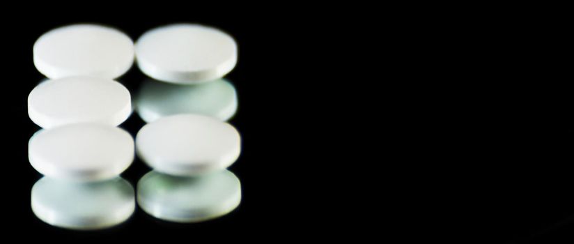 scattered tablets on a black background, pills reflected in the mirror, medicine