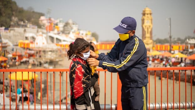 Haridwar, Uttarakhand India April 06, 2021. Policemen wearing protection mask to a child to stay safe from Coronavirus during Maha Kumbh 2021. Apple prores 422 High-quality 4k footage.