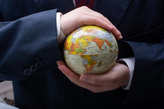 Businessman is standing with an earth globe fot business concept