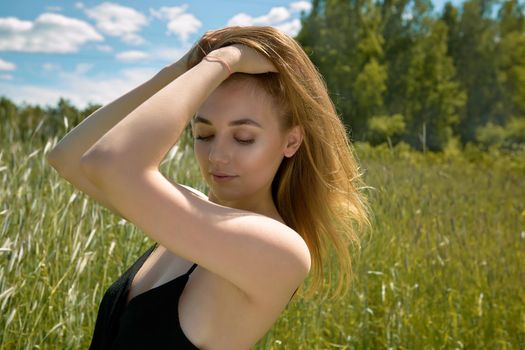 young woman walking in a green field on a sunny day