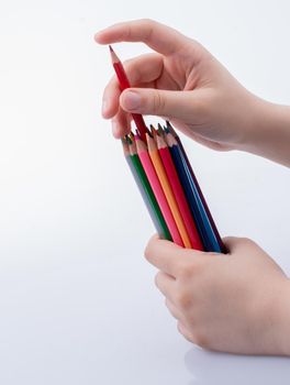 Hand holding color Pencils placed on a white background