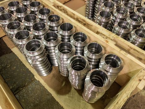 stacks of batch production round parts in a wooden boxes on factory floor, close-up