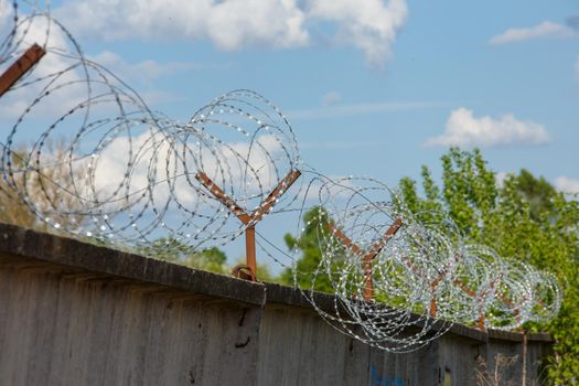 close-up view of barb wire over concrete fence.