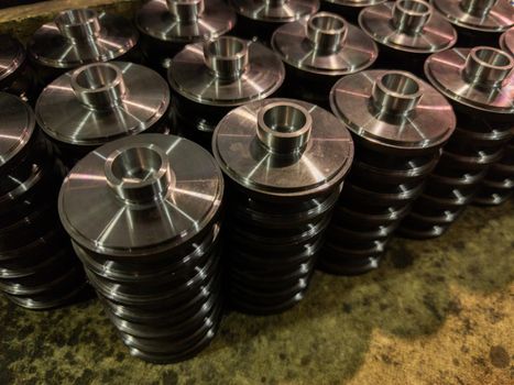 stacks of batch production round parts in a wooden box, close-up