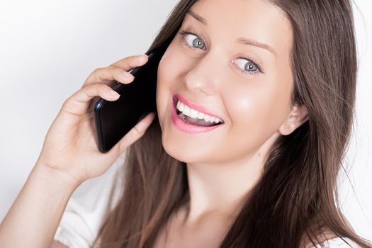 Happy smiling woman calling on smartphone, portrait on white background. People, technology and communication concept.