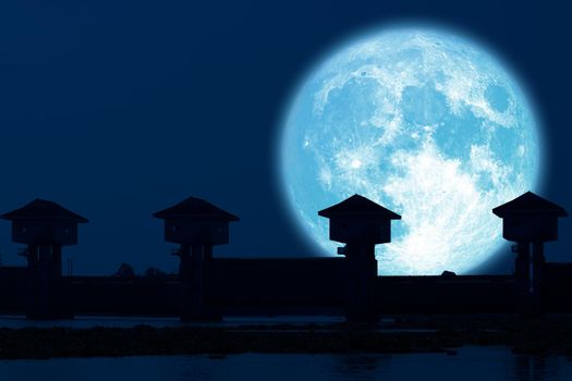 reflection full blue moon and silhouette dam in the dark night sky, Elements of this image furnished by NASA