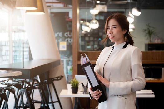 Portrait of successful young Asian businesswoman with working space at office,