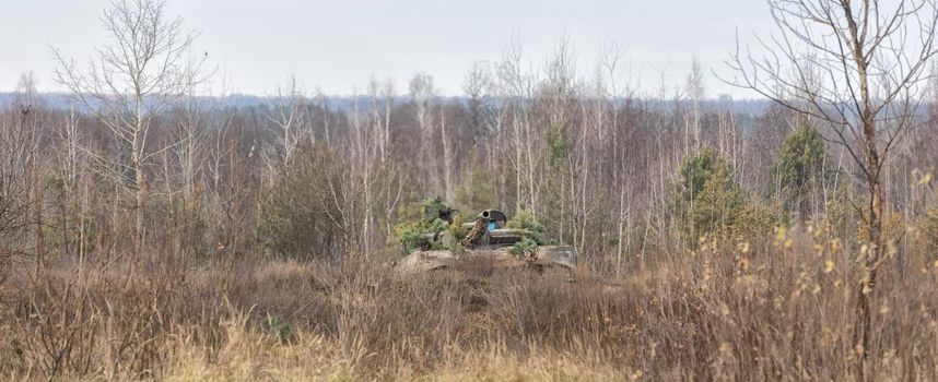 ZHYTOMYR Reg, UKRAINE - Nov. 21, 2018: Combat training at the training center of the airborne troops of the Ukrainian Armed Forces in Zhytomyr region. Tank disguised in the forest