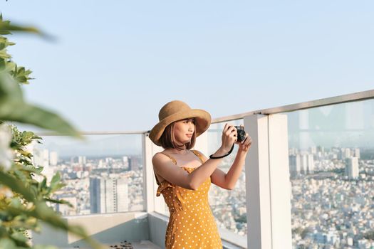 Asian Woman taking a photo using professional camera. Young photographer, natural light. 