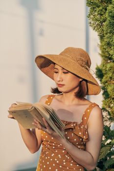 Portrait of young Asian girl is reading book in the park