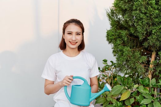 Smiling of young Asian woman watering plants