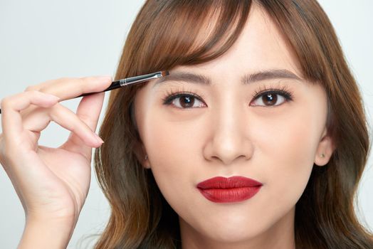 Asian young beautiful woman applying cosmetic powder brush on eyebrow, natural makeup, beauty face