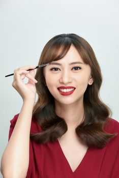 Asian young beautiful woman applying cosmetic powder brush on eyebrow, natural makeup, beauty face