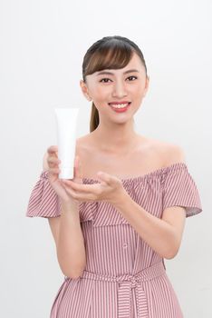 Portrait beautiful asian woman showing product with white cosmetic tube plastic