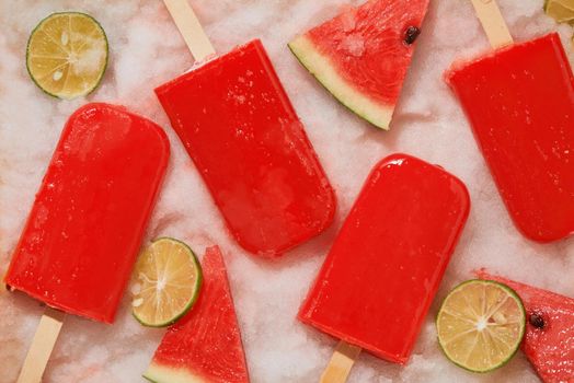 Watermelon popsicle and sliced lemon on ice tray