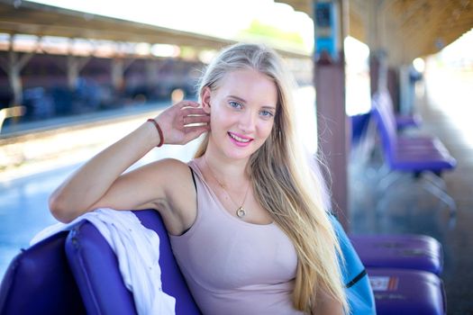 young woman waiting in vintage train, relaxed and carefree at the station platform in Bangkok, Thailand before catching a train. Travel photography. Lifestyle.