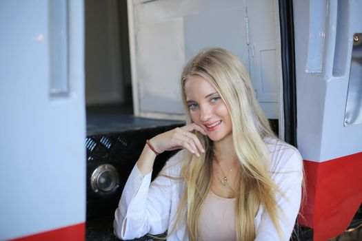 young woman waiting in vintage train, relaxed and carefree at the station platform in Bangkok, Thailand before catching a train. Travel photography. Lifestyle.