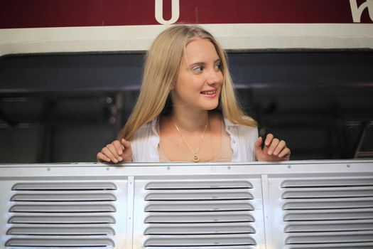 young woman waiting in vintage train, relaxed and carefree at the station platform in Bangkok, Thailand before catching a train. Travel photography. Lifestyle.