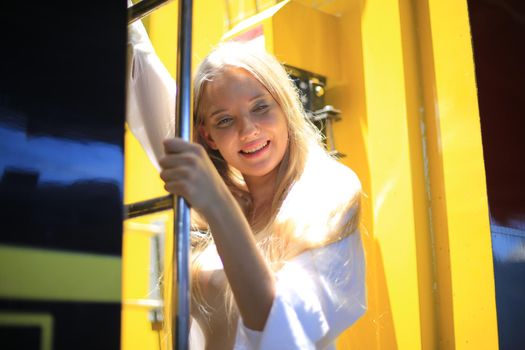 young woman waiting in vintage train, relaxed and carefree at the station platform in Bangkok, Thailand before catching a train. Travel photography. Lifestyle.