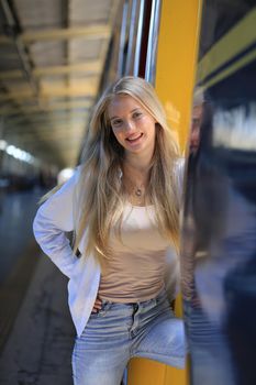 young woman waiting in vintage train, relaxed and carefree at the station platform in Bangkok, Thailand before catching a train. Travel photography. Lifestyle.