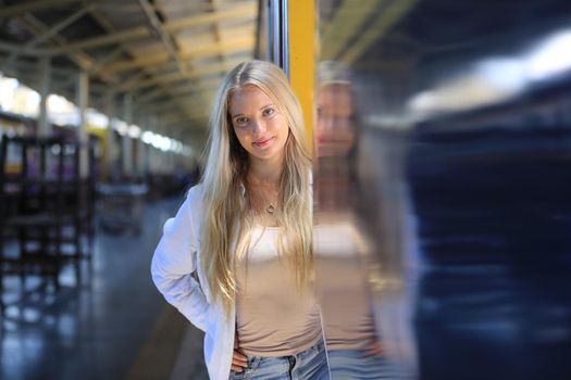 young woman waiting in vintage train, relaxed and carefree at the station platform in Bangkok, Thailand before catching a train. Travel photography. Lifestyle.