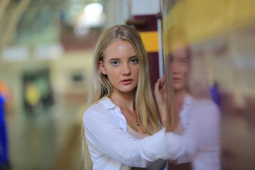 young woman waiting in vintage train, relaxed and carefree at the station platform in Bangkok, Thailand before catching a train. Travel photography. Lifestyle.