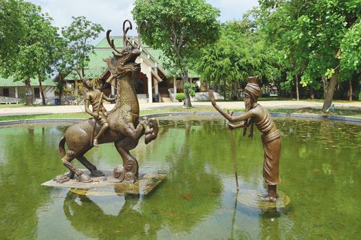 Rayong, Thailand - April 13, 2021: Sud Sakhon ride on Nil Mangkorn horse and hermit is main character in The famous Thai poet Phra Aphai Mani at Phra Sunthonwohan park in Rayong, Thailand.
