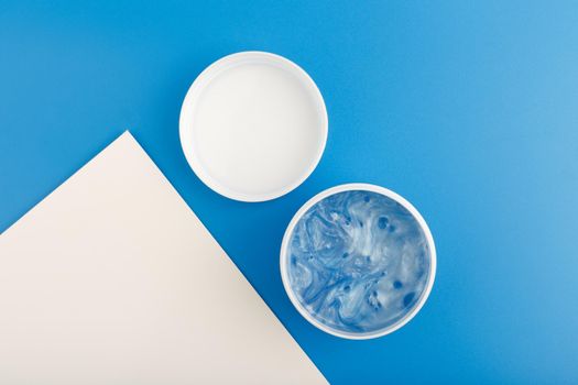 Top view of white opened jar with face or hair mask with sea minerals. 