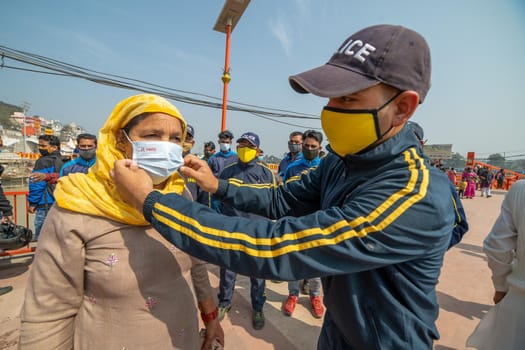 Haridwar, Uttarakhand India April 06, 2021. Policemen wearing protection mask to a woman to stay safe from Coronavirus during Maha Kumbh 2021. Apple prores 422 High-quality 4k footage.