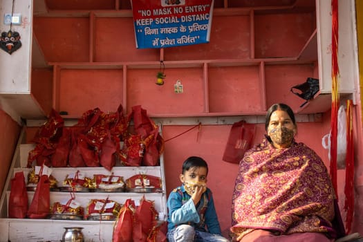 Haridwar, Uttarakhand, India, April 14, 2021.Indian woman shopkeeper with her child at shop selling religious material at Haridwar Uttarakhand India . High quality photo